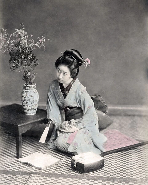 Geisha with fan reading a book, Japan, c. 1880 s