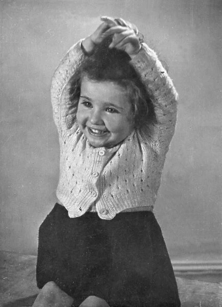 Happy little girl in a knitted cardigan