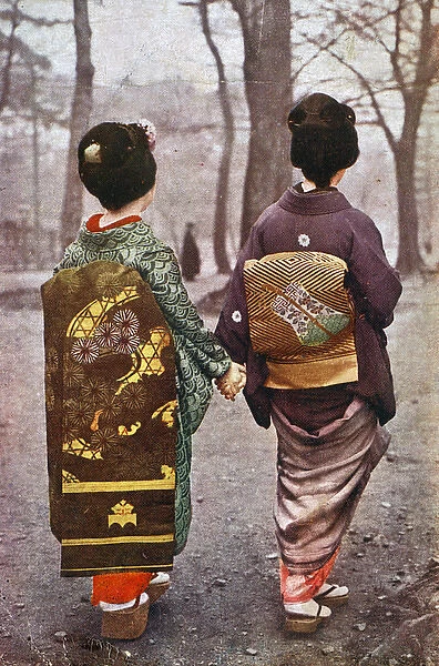 Two Japanese Geisha Girls walk hand in hand in the park