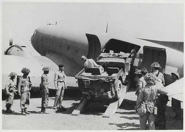 Jeep being loaded into the fuselage of a Dakota transport pl