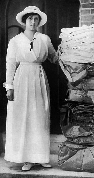 Lady Quilter with pile of comforts for troops, WW1