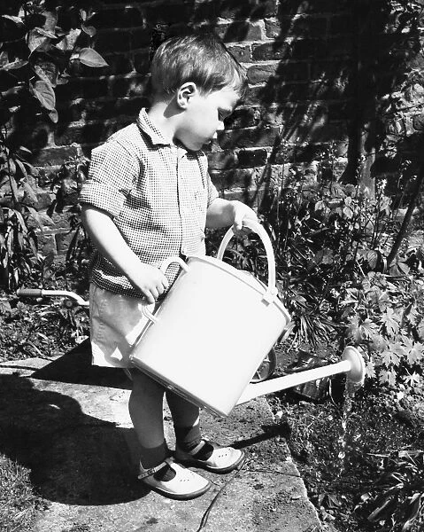 Little boy watering the garden