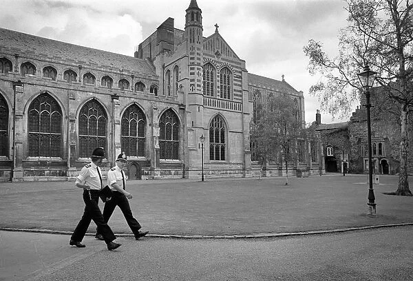 Two policemen march in step past Bury St Edmunds Abbey