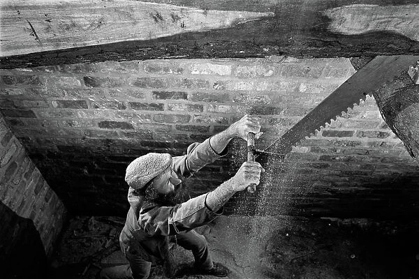 The bottom sawyer in a saw pit cutting a timber log into pla