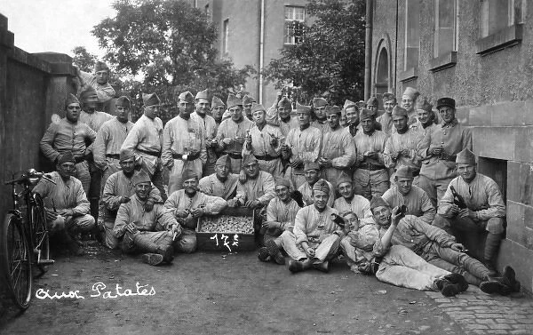 Soldiers posing for a photo with a box of potatoes