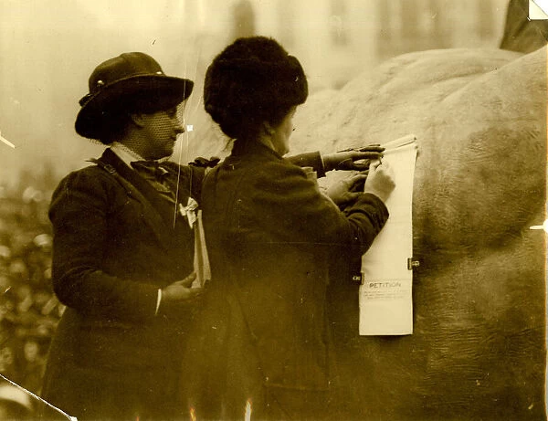 Two suffragettes signing a petition