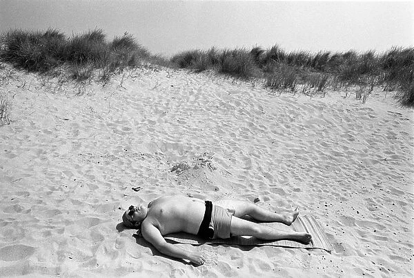 Sunbathing man on beach Newport, near Great Yarmouth
