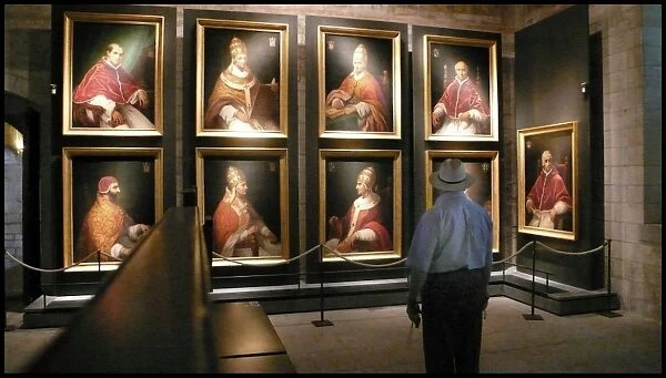 Tourist looking at portraits of Avignon popes, France