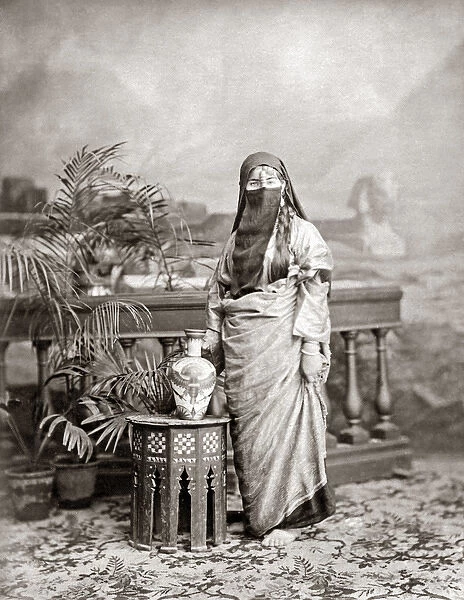 Veiled woman with ornate jug, Egypt, circa 1890