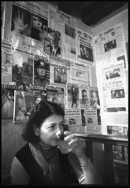 Woman in Paris cafe - walls covered in political posters