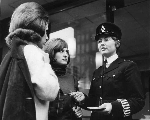 Woman police officer and two young women, London