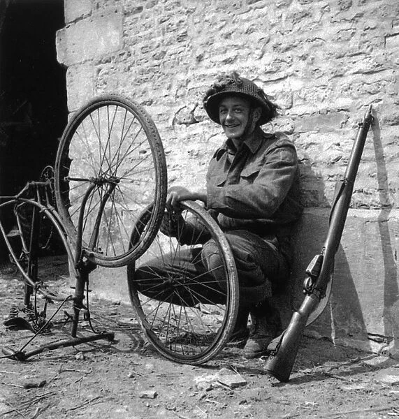 WW2 - Canadian Trooper repairing his bicycle in Normandy