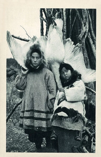 Two young Eskimo (Inuit) children with a captured goose