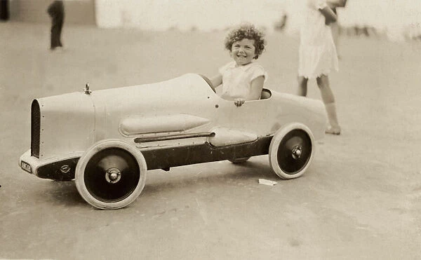 Young girl in model racing car