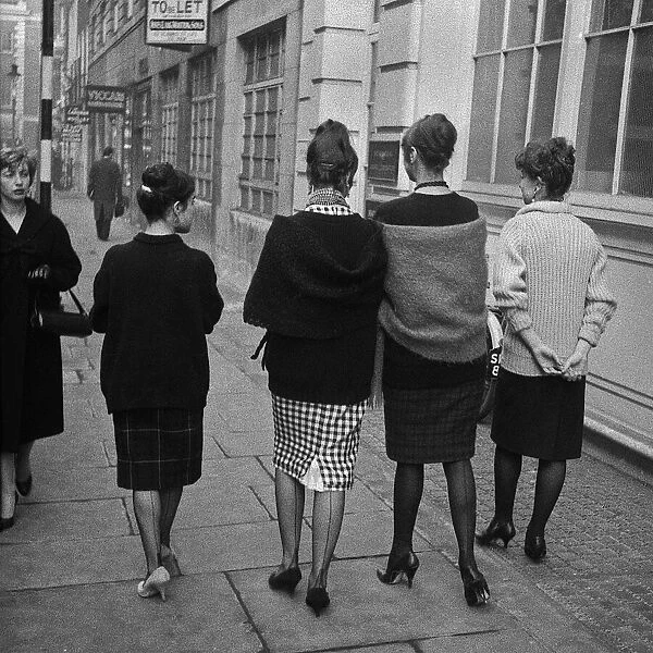 Four young women walking along a street, London