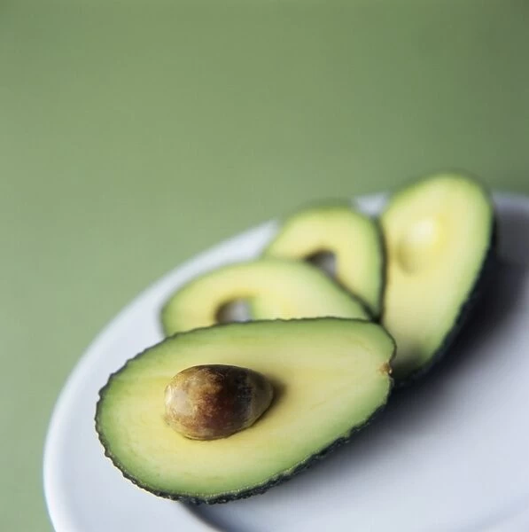 Avocado slices on a plate. The avocado is the fruit of the avocado tree (Persea americana)