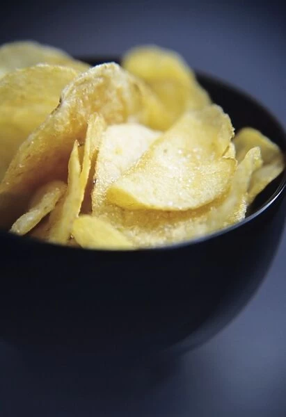 Crisps in a bowl. This junk food contains fat, so it is high in calories 