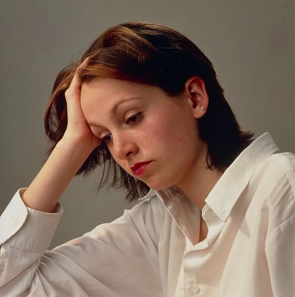 Head and shoulders of depressed woman in shirt