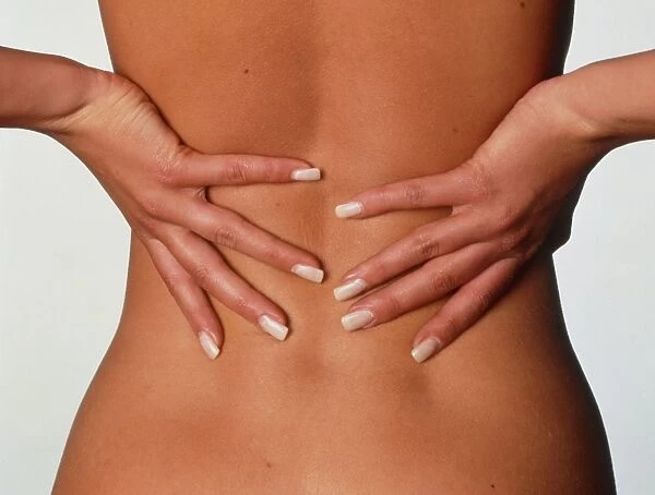 Back pain: womans hands held to her lower back