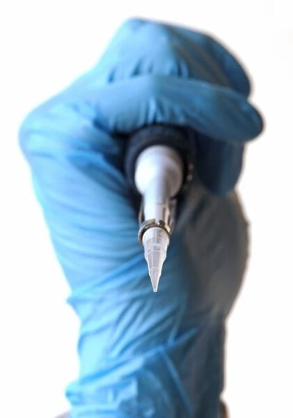 Pipette held in a gloved hand