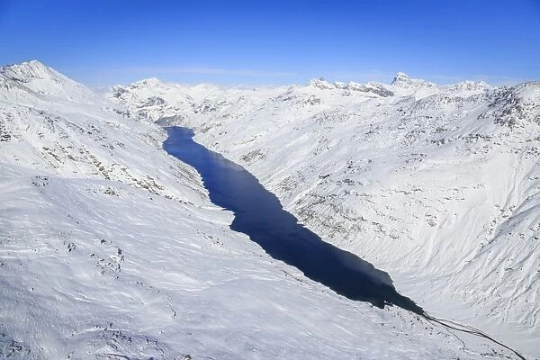 Aerial view of the alpine Lago di Lei surrounded by snow, Val di Lei, Chiavenna, Spluga Valley