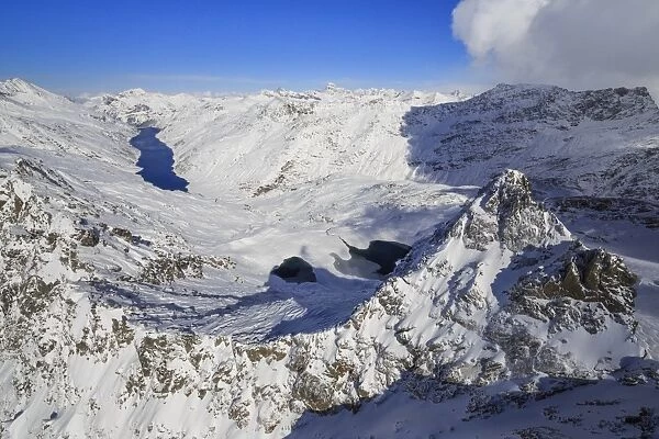 Aerial view of snowy Peak Peloso surrounded by Lago di Lei, Val di Lei Chiavenna