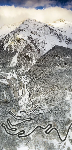 Bends of Maloja Pass road on snowy mountain ridge, aerial view, Bregaglia Valley