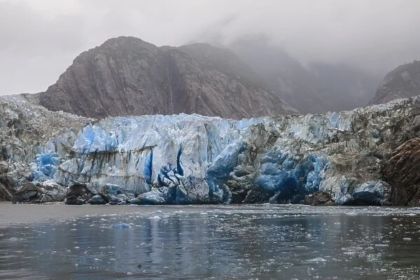 Blue ice face and floating ice, Sawyer Glacier and mountains, misty conditions, Stikine Icefield