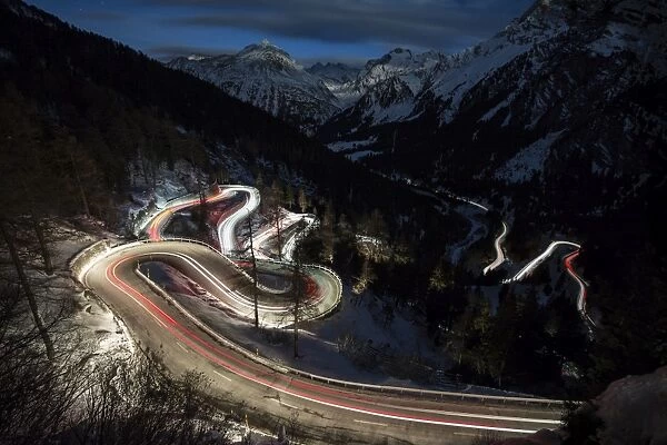 Car lights on the curvy Maloja Pass road at night, Maloja Pass, Engadine, Province of Graubunden