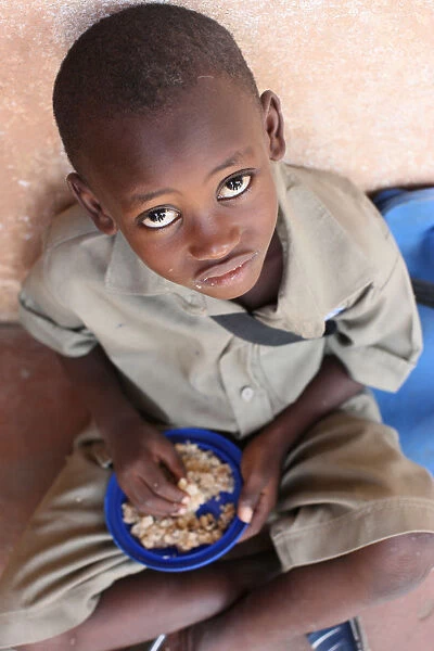 Child eating a meal in a primary school in Africa, Lome, Togo, West Africa, Africa