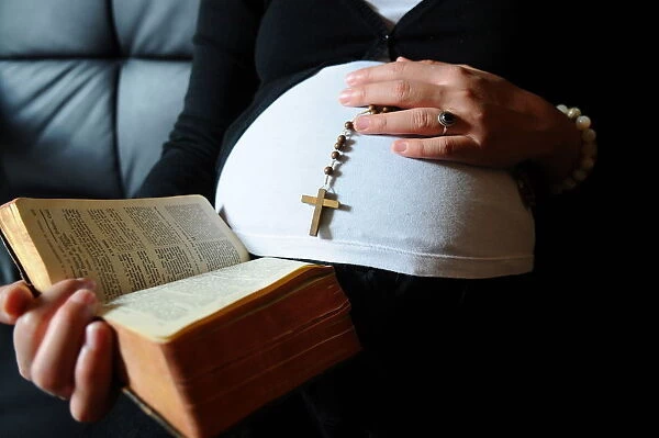 Christian pregnant woman reading the Bible, Paris, France, Europe