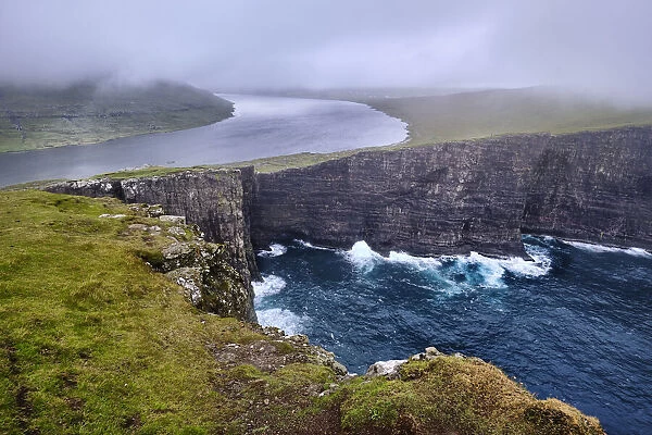 Cliffs of Traelanipa with the lake above the ocean, Faroe Islands, Denmark, Europe