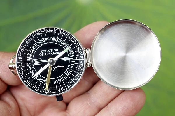 Close-up of a Muslim using a Qibla compass to indicate the direction of Al Kaaba