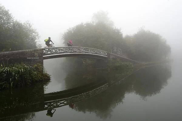 A cyclist on a bridge on Birmingham Canal Navigations (BCN), Birmingham, West Midlands