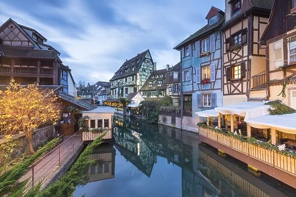Dusk lights on houses reflected in River Lauch at Christmas, Petite Venise, Colmar