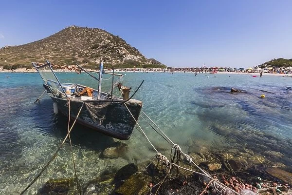 A fishing boat in the turquoise sea surrounding the sandy beach, Punta Molentis, Villasimius