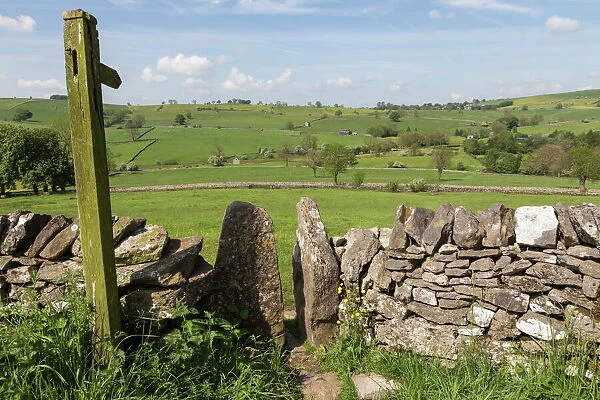 Footpath sign and stone stile with dry stone wall, near Alstonefield, Peak District National Park, Staffordshire, England, United Kingdom, Europe