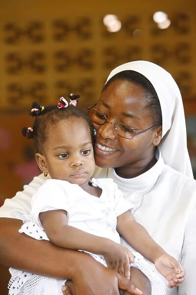 Franciscan sister holding an orphan at nursery and kindergarten run by Catholic nuns