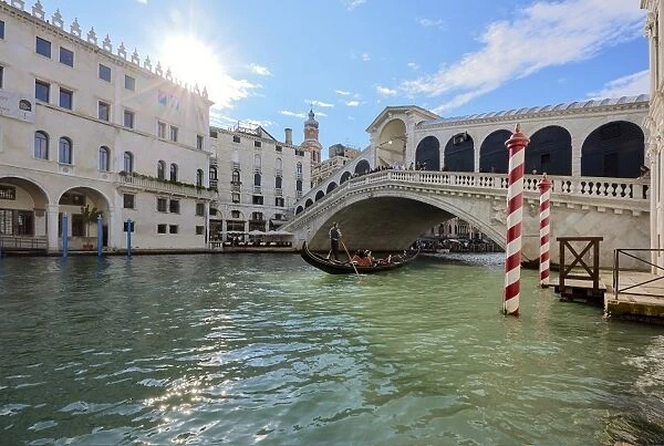 A gondolier rowing under Rialto Bridge in Venice, UNESCO World Heritage Site, Veneto