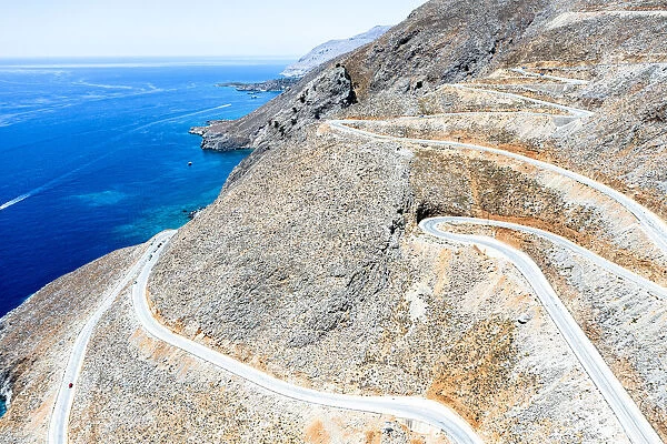 Hairpin bends of mountain road leading to the blue sea, aerial view, Crete island, Greek Islands, Greece, Europe