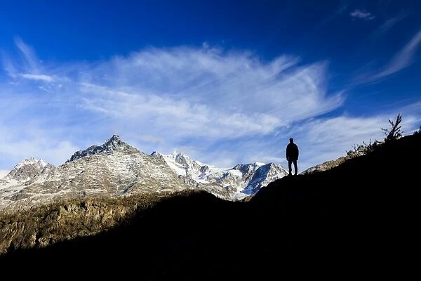 Hiker admires Monte Disgrazia from Lake Mufule, Malenco Valley, Province of Sondrio
