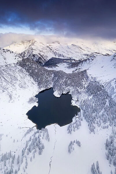 Lake Cavloc surrounded by snow, aerial view, Bregaglia Valley, Engadine