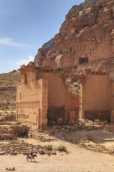 Local man on donkey passes Qasr al-Bint temple, elevated view, City of Petra ruins