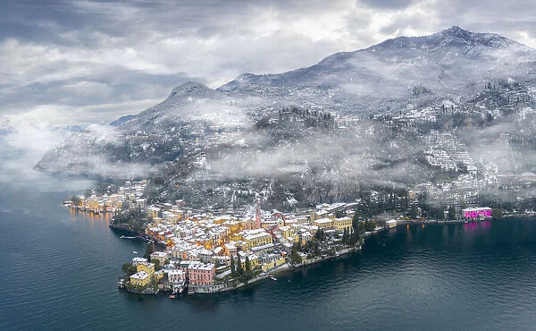 Mist over Varenna old town and Lake Como after a snowfall in winter, aerial view