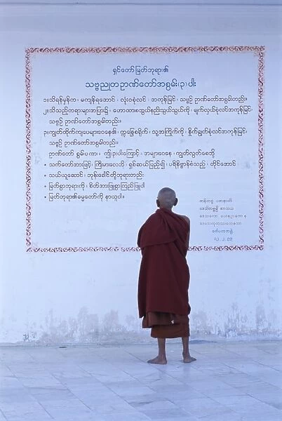 Monk reading Burmese wall script, Shwedagon, Yangon (Rangoon), Myanmar (Burma), Asia
