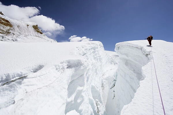 Mountain guide traversing a crevasse, Island Peak, 6189m, Solu Khumbu Everest Region