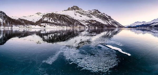 Panoramic view of the icy surface of Lake Sils at sunrise, Engadine Valley, Graubunden