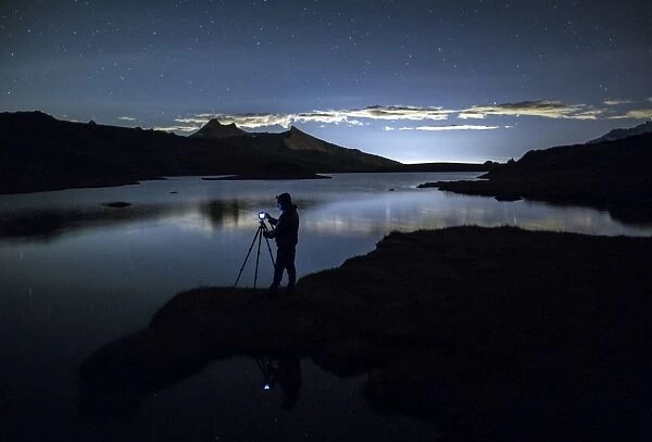 Photographer admires reflection on Rossett Lake at night, Gran Paradiso National Park