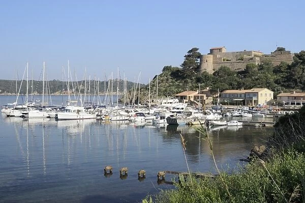 Sailing yachts and other boats moored at Port Cros Island in front of Fort de l Eminence castle, Hyeres archipelago, Var, Provence, Cote d Azur, France, Europe