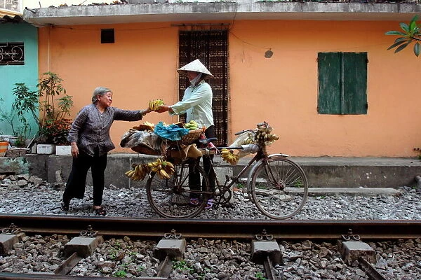 Selling bananas by the railway tracks in central Hanoi